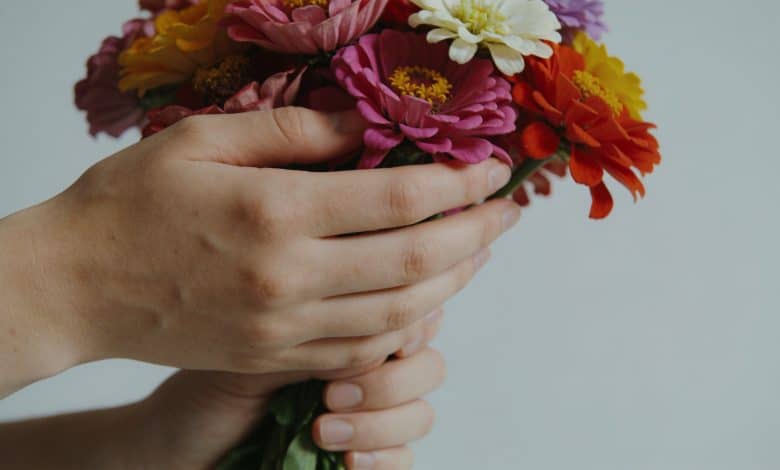 Gros plan mains tenant bouquet fleurs multicolores