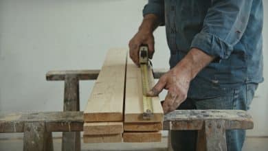 Ouvrier mesure planches bois pour grand bac potager
