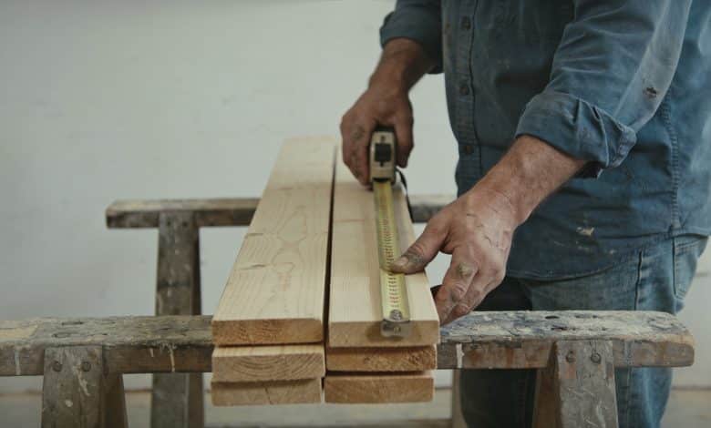 Ouvrier mesure planches bois pour grand bac potager