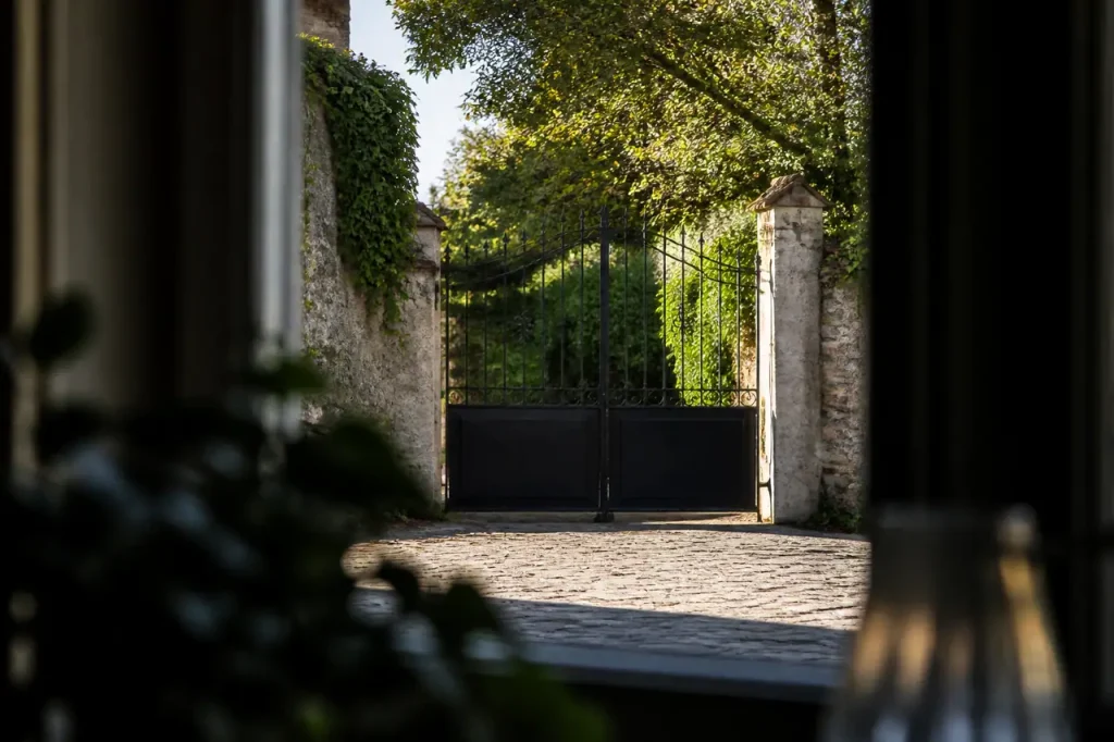 Deux hommes discutent devant un portail en fer noir