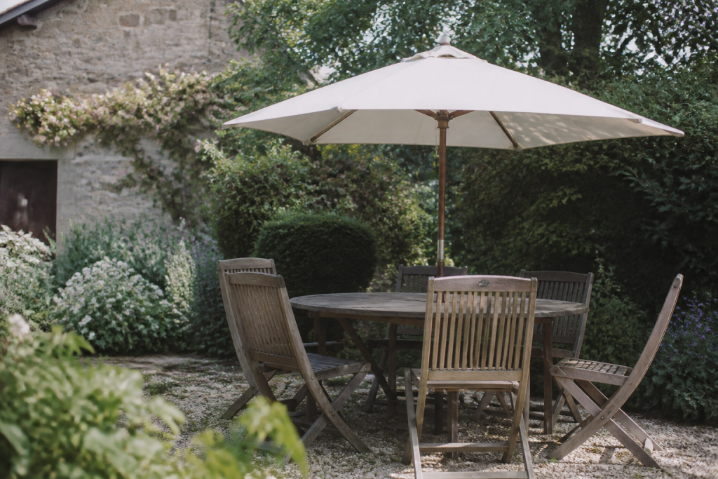 Table de jardin avec chaises en bois et parasol